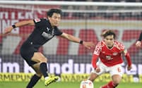 競り合うボルシアMGの町野㊧とマインツの佐野海(5日、マインツ)=共同