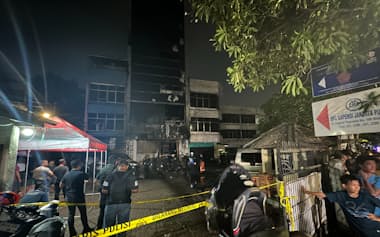 火災のあったビルには鎮火後も警官などが詰めかけ、物々しい雰囲気に包まれていた(9日、ジャカルタ)