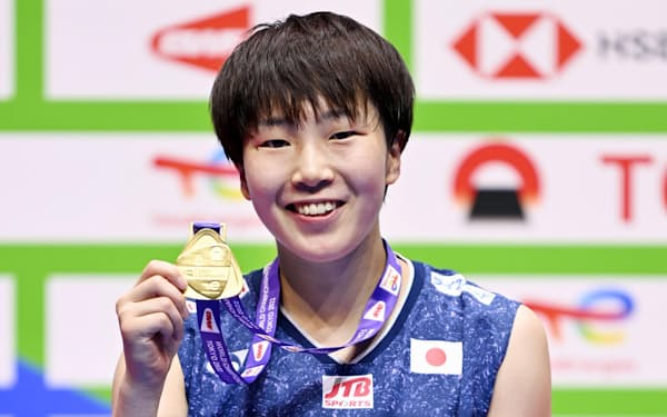 バドミントンの世界選手権女子シングルスで2連覇を果たし、金メダルを手に笑顔の山口茜（28日、東京体育館）＝共同
