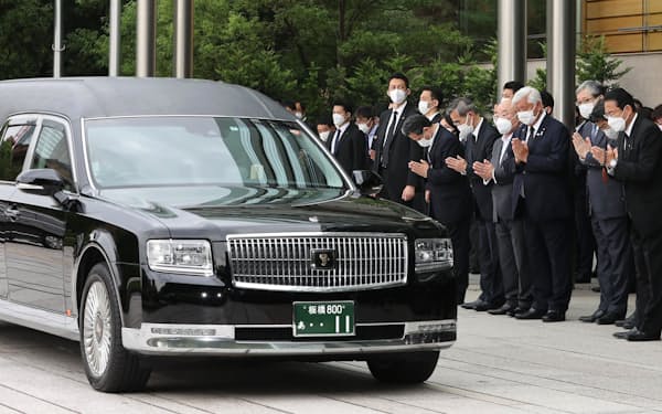 首相官邸の玄関前で安倍元首相のひつぎを乗せた車に手を合わせる岸田首相ら（12日）