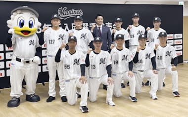 ロッテの新入団記者会見で記念写真に納まる(前列左から)桜井ユウヤ内野手、毛利海大投手、石垣元気投手、奥村頼人投手、冨士隼斗投手。(後列左から)高橋快秀投手、田中大聖投手、サブロー監督、岡村了樹捕手、中山優人投手、杉山諒外野手(11日、東京都新宿区)=共同