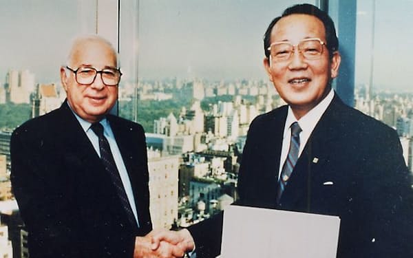 米AVX社のバトラー会長（左）と握手を交わす稲盛和夫氏