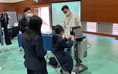 児島中学校の生徒がデニム生地のボタン付けなどを体験した(12日、岡山県倉敷市)