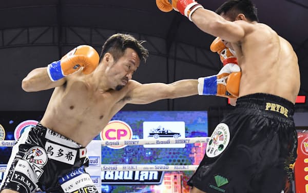 WBCミニマム級タイトルマッチで、パンヤ・プラダブシー（右）を攻める田中教仁（31日、ナコンラチャシマ）＝共同