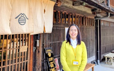 日野百草本舗奈良井店と石黒和佳子社長。着ている服はキハダで染めたものだ