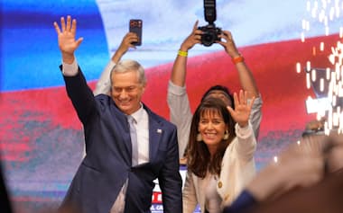 支持者らを前に勝利を宣言するカスト氏㊧(14日、サンティアゴ)=AP