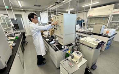 吸着剤の性能試験をするカーボンクライオキャプチャーのスタッフ(10日、茨城県つくば市の物質・材料研究機構で)