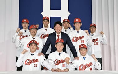 広島の新入団選手発表記者会見でポーズをとる(前列左から)斉藤汰直投手、平川蓮外野手、勝田成内野手、(2列目左から)工藤泰己投手、新井監督、赤木晴哉投手、(3列目左から)小林結太捕手、西川篤夢内野手、高木快大投手、岸本大希内野手(15日、広島市)=共同