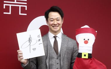契約交渉を終え、笑顔で写真撮影に応じる巨人の中川(15日、東京都内の球団事務所)=共同