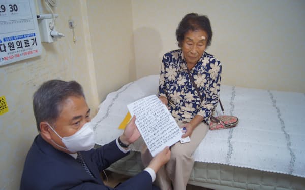 三菱重工の元挺身隊員だった女性（右）から手紙を受け取る韓国の朴振外相（2日、韓国・光州）＝代表撮影