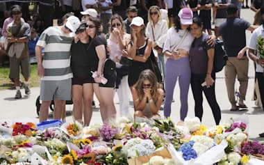 オーストラリア・シドニーのボンダイビーチ付近で、銃乱射事件の犠牲者を追悼する人たち(15日)=AP・共同
