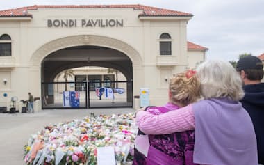 銃撃テロが発生したボンダイビーチで犠牲者を悼む人々(16日、シドニー近郊)=ロイター