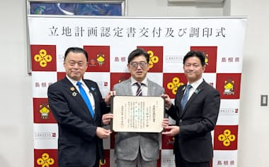 丸山達也知事㊧から立地計画認定書の交付を受け、記念撮影するピーエスシーの鈴木正之社長㊥ら(16日、島根県庁)