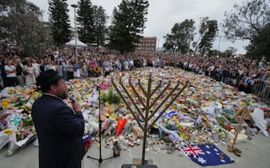 テロ事件が起きたボンダイビーチで犠牲者を悼む人々(16日、シドニー)=AP