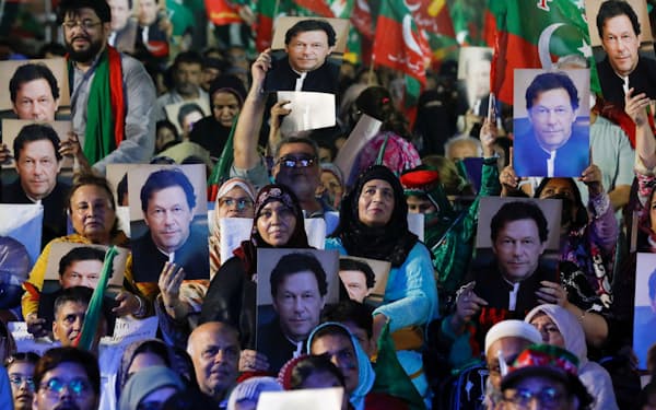 ６月、パキスタン・カラチでイムラン・カーン氏のオンライン演説を聞くために同氏のポスターを手に集まったＰＴＩ支持者＝ロイター