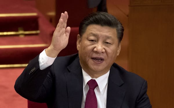 FILE - Chinese President Xi Jinping raises his hand to show approval of a work report during the closing ceremony for the 19th Party Congress at the Great Hall of the People in Beijing on Oct. 24, 2017. China's long-ruling Communist Party on Tuesday, Aug. 30, 2022, set October 16 for its 20th party congress, at which leader Xi is expected to be given a third five-year term. (AP Photo/Ng Han Guan, File)