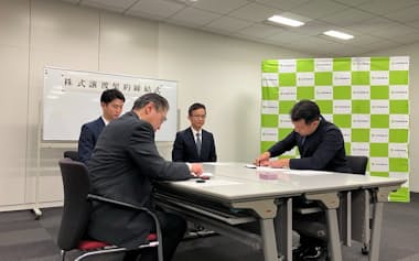 つけしん㊧と十色屋商店は株式譲渡契約を締結した(17日、さいたま市)