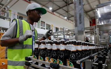 イースト・アフリカン・ブリュワリーズの醸造所で商品を検査する従業員(2024年1月)=ロイター