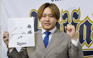 契約更改を終え、来季の目標を書いた色紙を手にポーズをとるオリックスの宮城(18日、大阪市)=共同