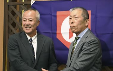 握手を交わす野球のU-18高校日本代表の岡田龍生新監督㊧と小倉全由前監督(18日、大阪市)=共同