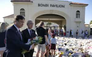 犠牲者を悼み、献花する堀井巌外務副大臣㊧と鈴木量博駐豪日本大使(19日、ボンダイビーチ) 犠牲者を悼み、献花する堀井巌外務副大臣㊧と鈴木量博駐豪日本大使(19日、ボンダイビーチ)