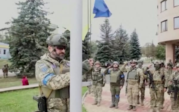 イジューム北西のバラクレヤを奪還し、国旗を掲げるウクライナ軍兵士（10日）=ウクライナ国防省・ロイター