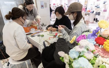 ポップアップ店舗「hanamaru flower」でモールフラワー作り体験をする客(東京都新宿区のルミネ2)