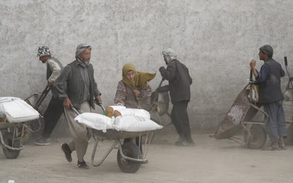アフガニスタンの首都カブールで食料配給を受ける人々（5月）=AP
