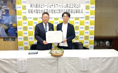 連携協定を結んだリージョナルフィッシュの梅川忠典社長㊨と、鹿児島県阿久根市の西平良将市長(24日、同市役所)