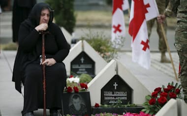 ロシアによる2008年の旧ソ連圏ジョージア侵攻こそ21世紀がどんな世紀になるかを示す出来事だったと筆者は指摘する(ジョージアの首都トビリシの記念墓地に眠る兵の死を悲しむ遺族)=ロイター