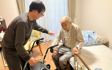 おじの嶋田希見さんを介護する昭彦さん㊧。希見さんは要介護2で移動に歩行器が必要(埼玉県戸田市のSOMPOケア「ラヴィーレ戸田」)