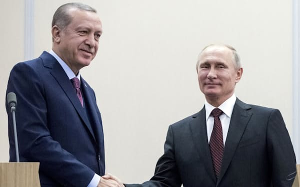 ロシアのプーチン大統領（右）と握手するトルコのエルドアン大統領（2017年、ロシア南部ソチ）＝ロイター