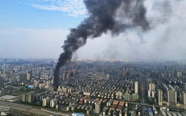 大規模な火災が発生した中国湖南省長沙市中心部に立ち上る黒煙（16日）＝共同