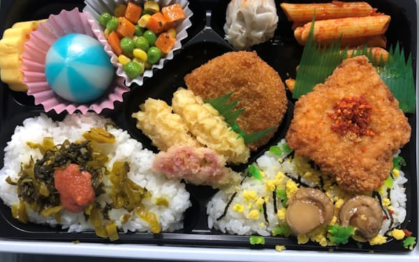 北海道と九州、新庄監督ゆかりの地の名物を満載したBIGBOSS弁当は遊園地のような華やぎ。左上の青い球体は「べこ餅」という北海道のおやつ