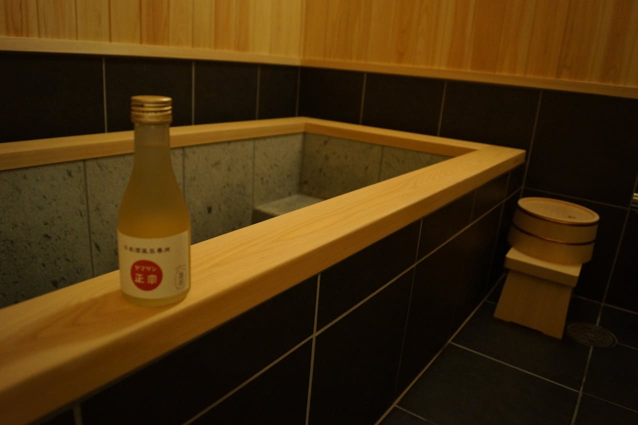 入浴剤のようにして使う入浴酒を注いで「日本酒風呂」を楽しんでもらう