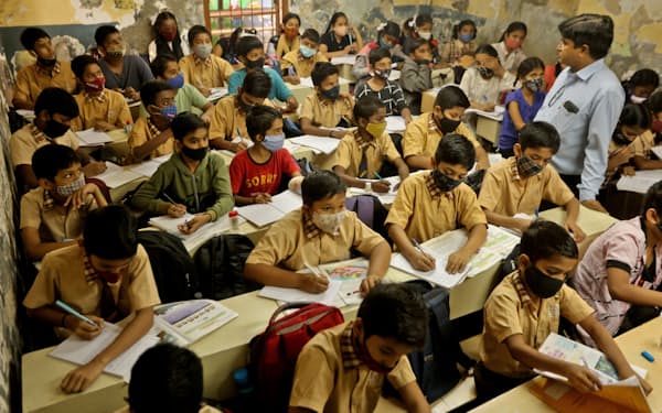 再開されたインド・ムンバイの学校で授業を受ける子どもたち＝ロイター