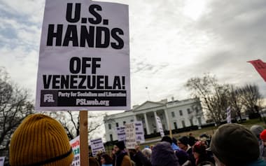 ホワイトハウス前で米軍によるベネズエラへの攻撃に抗議するデモ参加者=ロイター