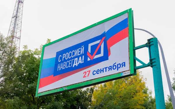 ルガンスク州の通りには「ロシアとともに永遠に、９月２７日」と描かれた広告が飾られた＝ＡＰ