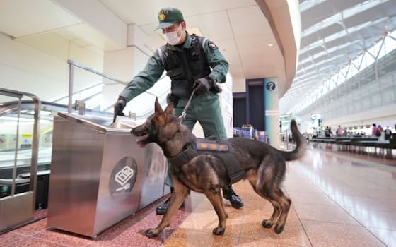 羽田空港内で不審物などの警戒にあたる警察犬と警察官（24日午前、東京都大田区）