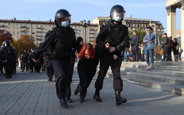 部分動員令に抗議するデモの参加者を拘束する警察官（24日、ロシア・ノボシビルスク）=タス共同