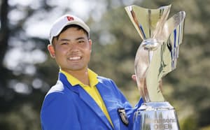 男子ゴルフのパナソニック・オープンで優勝し、笑顔でトロフィーを掲げるアマチュアの蟬川泰果（25日、兵庫県の小野東洋GC）=共同