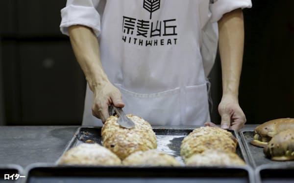 パンをつかむ職人(2015年、北京)=ロイター