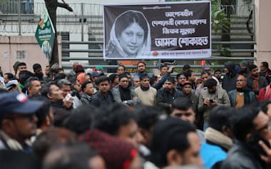 ダッカ市内で亡くなったジア元首相の死を悼み、元首相の写真を載せたバナーの前に集まった支持者たち=ロイター