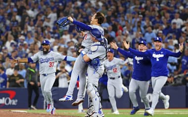 ブルージェイズとのワールドシリーズ第7戦を制して2連覇を達成し、捕手スミスに抱きかかえられるドジャースの山本由伸(2025年11月2日、トロント)=ゲッティ共同
