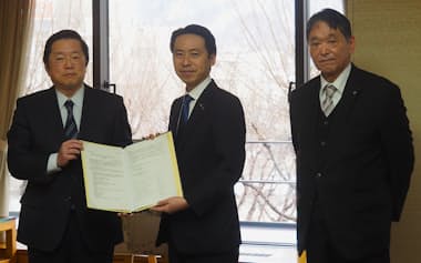 山形市の佐藤市長㊥は市の宿泊税の制度のあり方に関する報告書を受け取った(8日、市役所)