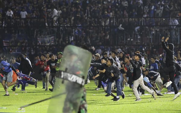 １日、インドネシア東ジャワ州のサッカー場で、グラウンドに乱入する観客ら＝ＡＰ