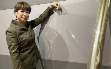 トーメッドのフィルムを広げるISTの阪根利子社長(14日、大津市)