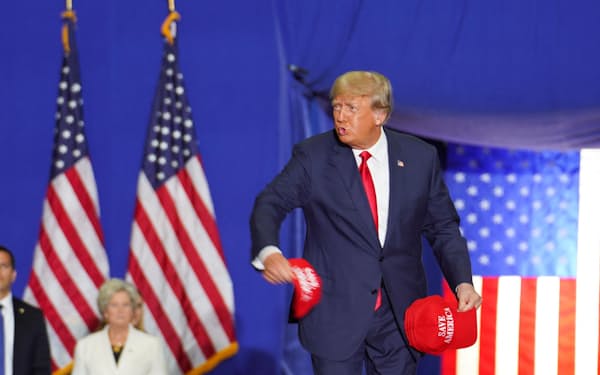 米ミシガン州での集会で、帽子を投げるトランプ前米大統領＝ロイター