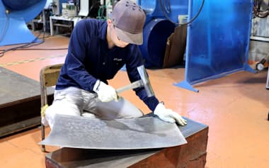 ハンマーをたたいて曲線形状をつくっていく「打ち出し加工」