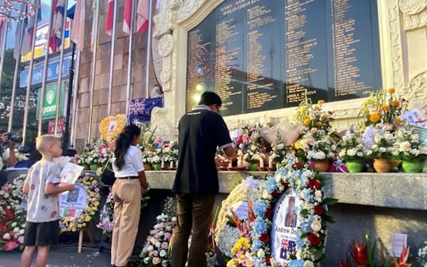 2002年バリ島テロから20年の式典で現場近くの記念碑に花を手向ける参加者（12日、バリ島）